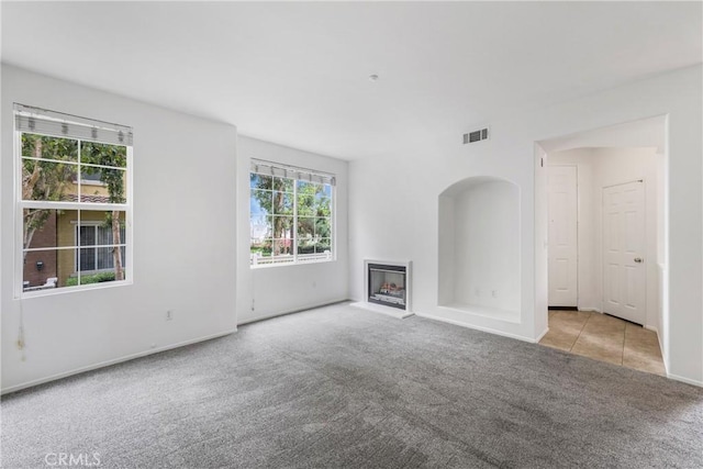 614 Timberwood, Irvine, CA 92620 - unfurnished living room featuring carpet flooring, a fireplace with raised hearth, baseboards, and tile patterned floors