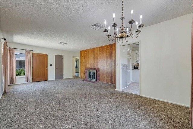 436 W Porter Ave, Fullerton, CA 92832 - unfurnished living room with a textured ceiling, a chandelier, carpet, wood walls, and baseboards