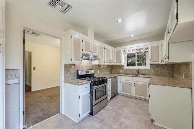 436 W Porter Ave, Fullerton, CA 92832 - kitchen featuring appliances with stainless steel finishes, under cabinet range hood, a sink, light stone countertops, and white cabinetry