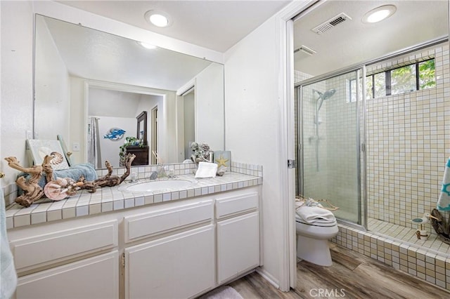 34101 Via California Unit 12, San Juan Capistrano, CA 92675 - bathroom featuring toilet, wood finished floors, a shower stall, vanity, and recessed lighting