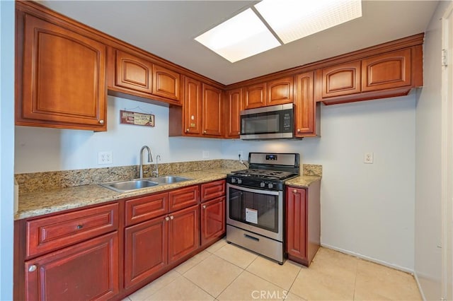 13905 Magnolia St, Garden Grove, CA 92844 - kitchen with stainless steel appliances, light tile patterned flooring, light stone countertops, and brown cabinetry