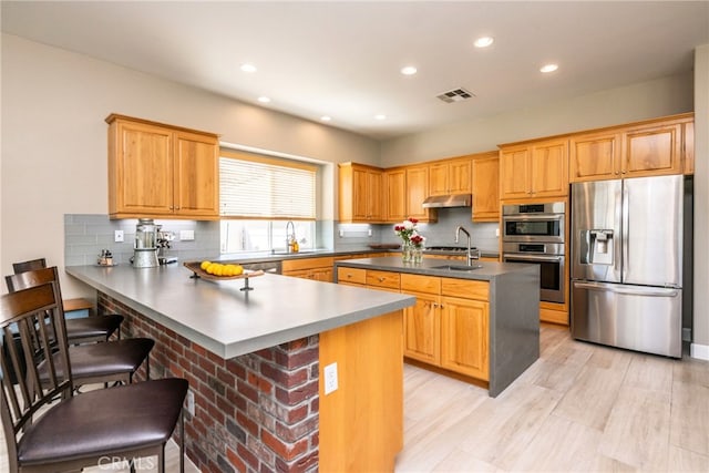 23840 Costa Mesa Way, Murrieta, CA 92562 - kitchen with stainless steel appliances, a peninsula, recessed lighting, a breakfast bar, and tasteful backsplash