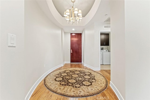 402 Rockefeller Unit 407, Irvine, CA 92612 - foyer entrance with a chandelier, light wood-style flooring, baseboards, and independent washer and dryer