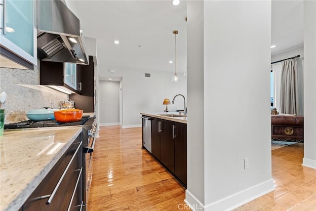 402 Rockefeller Unit 407, Irvine, CA 92612 - kitchen featuring a sink, stainless steel appliances, wall chimney range hood, tasteful backsplash, and baseboards