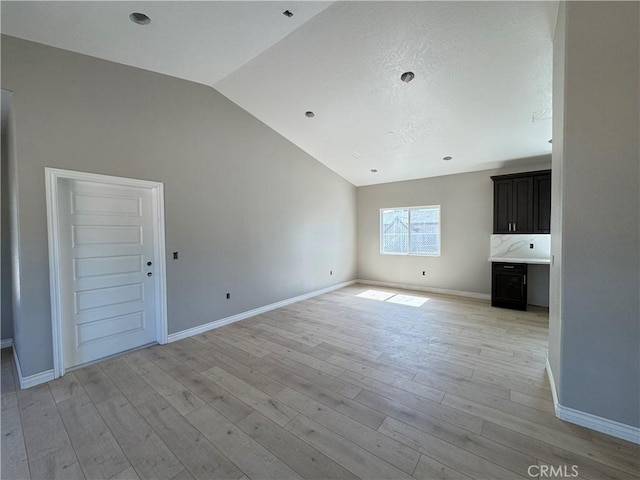 16063 Spruce St, Hesperia, CA 92345 - unfurnished living room featuring vaulted ceiling, light wood-style floors, and baseboards