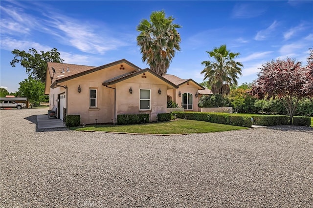 11576 Meridian Rd, Chico, CA 95973 - view of front facade featuring stucco siding, a front lawn, gravel driveway, and an attached garage