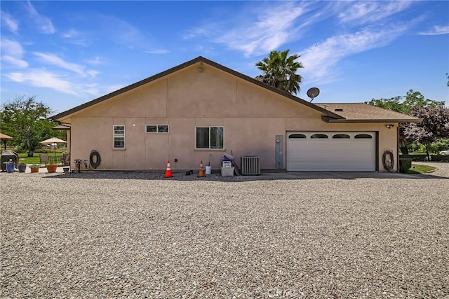 11576 Meridian Rd, Chico, CA 95973 - view of side of home with a garage, stucco siding, gravel driveway, and central AC