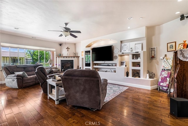 11576 Meridian Rd, Chico, CA 95973 - living room with dark wood-style flooring, ceiling fan, a glass covered fireplace, built in shelves, and recessed lighting