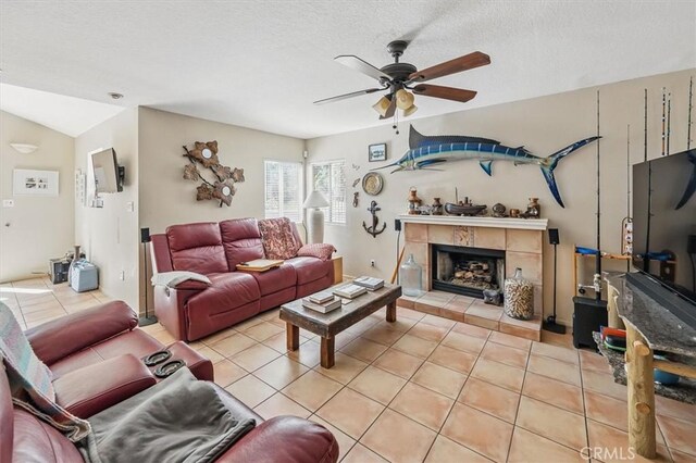 28532 Forest Meadow Pl, Castaic, CA 91384 - living room with a ceiling fan, light tile patterned floors, a tiled fireplace, and a textured ceiling