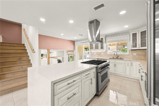 241 S Solomon Dr, Anaheim, CA 92807 - kitchen with stainless steel stove, island range hood, a sink, a kitchen island, and backsplash