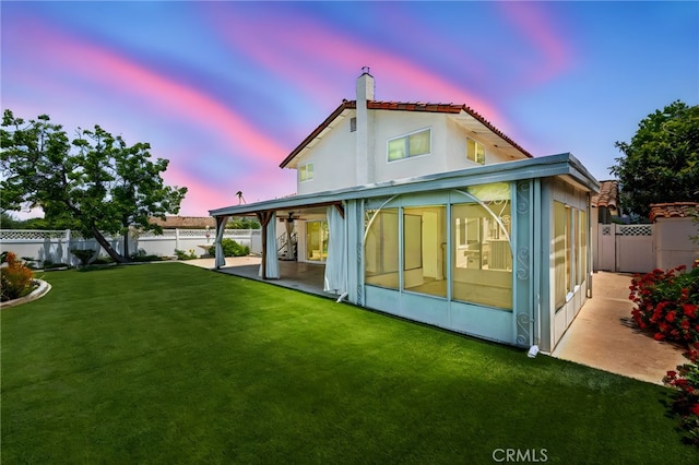 241 S Solomon Dr, Anaheim, CA 92807 - back of property at dusk with a patio, a sunroom, and a chimney