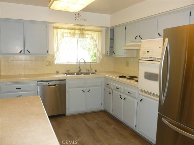 26276 Foxgrove Rd, Menifee, CA 92586 - kitchen with appliances with stainless steel finishes, a sink, wood finished floors, tasteful backsplash, and under cabinet range hood