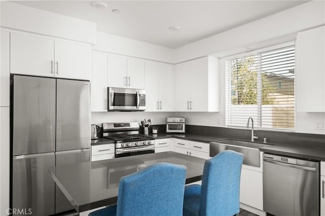1924 N Floret Dr, Los Angeles, CA 90222 - kitchen featuring appliances with stainless steel finishes, a sink, dark countertops, and white cabinetry