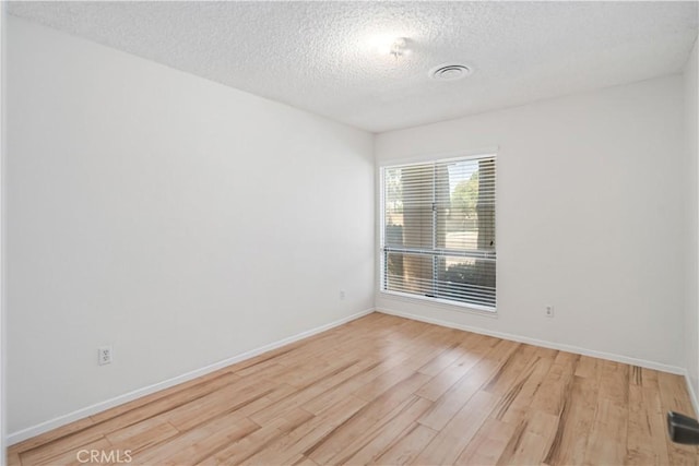 44114 30th St W, Lancaster, CA 93536 - spare room featuring light wood-type flooring, a textured ceiling, and baseboards