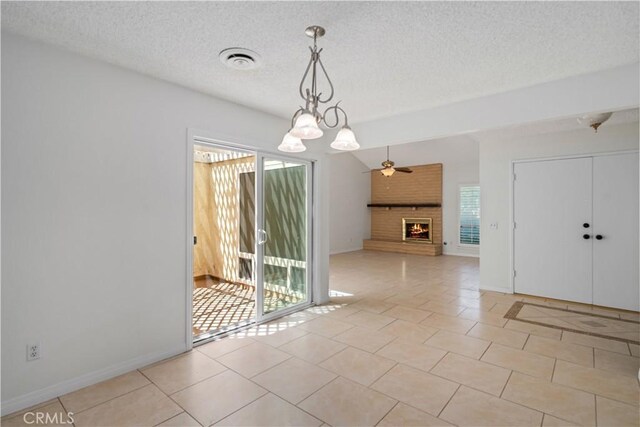 44114 30th St W, Lancaster, CA 93536 - empty room with a brick fireplace, a textured ceiling, a chandelier, baseboards, and light tile patterned floors