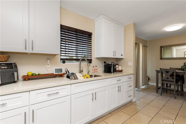 901 S Clymar Ave, Compton, CA 90220 - kitchen featuring white cabinetry, light tile patterned flooring, light countertops, and a sink