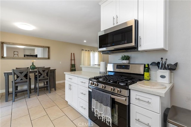 901 S Clymar Ave, Compton, CA 90220 - kitchen featuring appliances with stainless steel finishes, light countertops, white cabinets, baseboards, and light tile patterned flooring