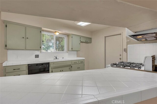 635 Brookdale Dr, Merced, CA 95340 - kitchen featuring black dishwasher, green cabinetry, tile counters, and decorative backsplash