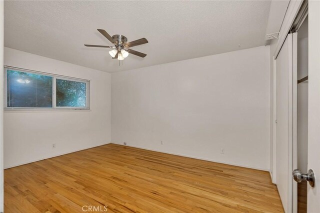 635 Brookdale Dr, Merced, CA 95340 - unfurnished bedroom featuring light wood-type flooring, a textured ceiling, and a ceiling fan