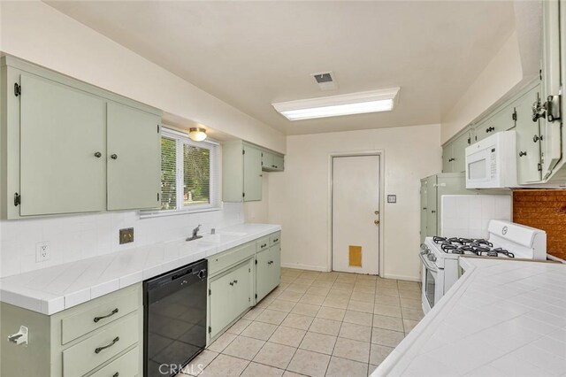 635 Brookdale Dr, Merced, CA 95340 - kitchen featuring white appliances, decorative backsplash, green cabinets, a sink, and tile counters