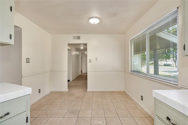 635 Brookdale Dr, Merced, CA 95340 - unfurnished dining area featuring light tile patterned flooring, plenty of natural light, and baseboards