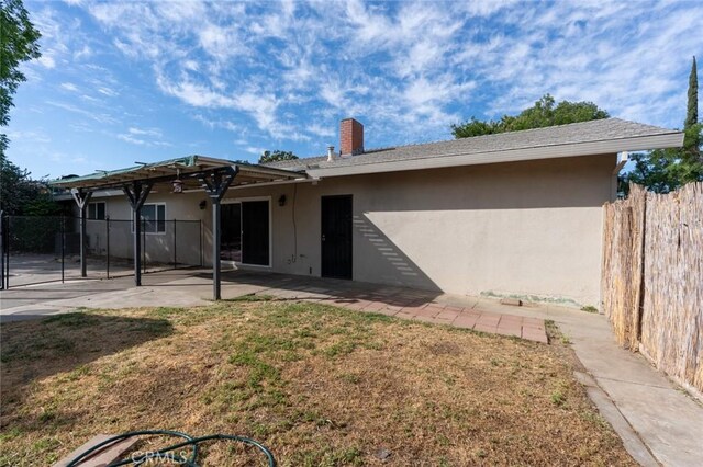 635 Brookdale Dr, Merced, CA 95340 - rear view of property featuring stucco siding, a patio area, and a chimney