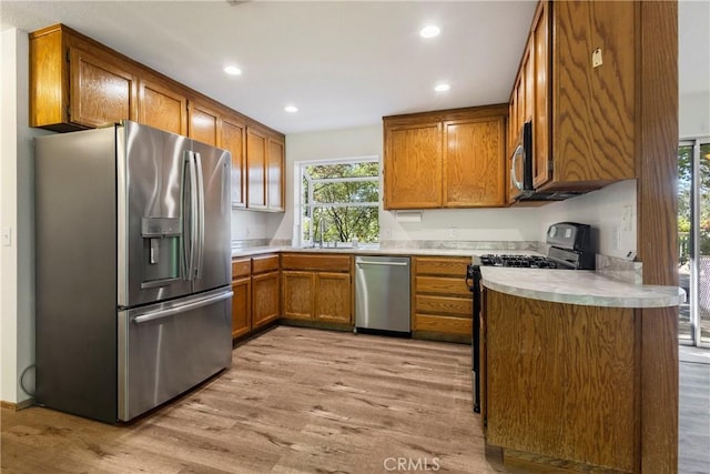 50 Walter Blume Ln, Oroville, CA 95966 - kitchen featuring appliances with stainless steel finishes, brown cabinets, light wood-style floors, plenty of natural light, and recessed lighting