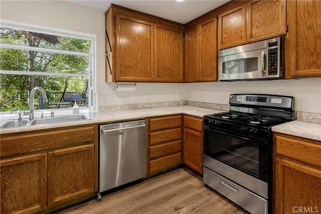 50 Walter Blume Ln, Oroville, CA 95966 - kitchen featuring appliances with stainless steel finishes, a sink, light wood-style flooring, and healthy amount of natural light