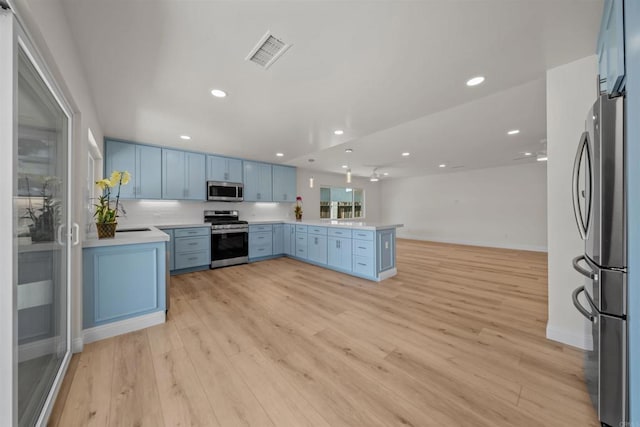 12632 Mcferon Rd, Poway, CA 92064 - kitchen featuring appliances with stainless steel finishes, blue cabinets, recessed lighting, light wood finished floors, and a peninsula