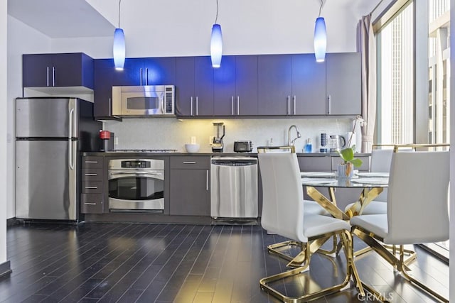 655 S Hope St Unit 903, Los Angeles, CA 90017 - kitchen with stainless steel appliances, decorative backsplash, dark wood-style flooring, and hanging light fixtures