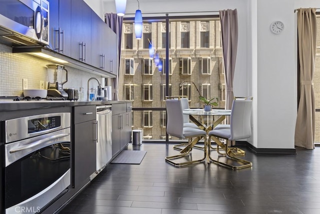 655 S Hope St Unit 903, Los Angeles, CA 90017 - kitchen with appliances with stainless steel finishes, dark wood-type flooring, and tasteful backsplash
