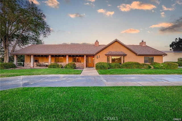 40052 18th St W, Palmdale, CA 93551 - view of front of property with a chimney, a lawn, and stucco siding