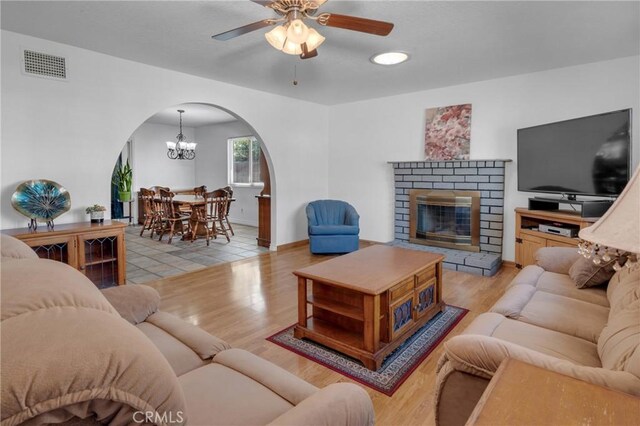 9945 Date St, Fontana, CA 92335 - living room featuring arched walkways, wood finished floors, a chandelier, and a fireplace