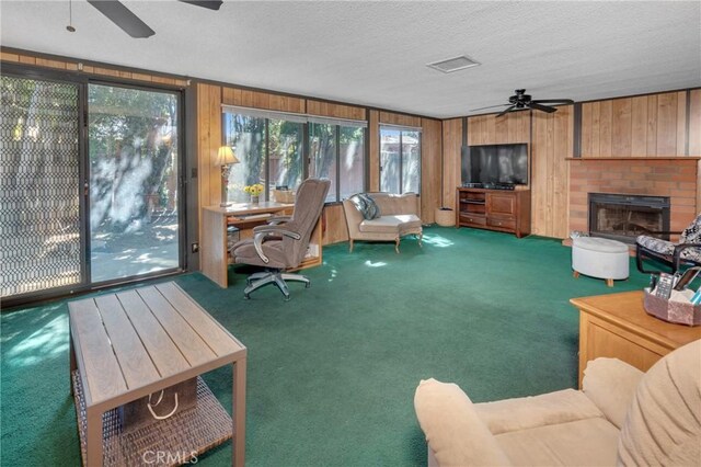9945 Date St, Fontana, CA 92335 - carpeted living area with a ceiling fan, wood walls, a textured ceiling, and a brick fireplace