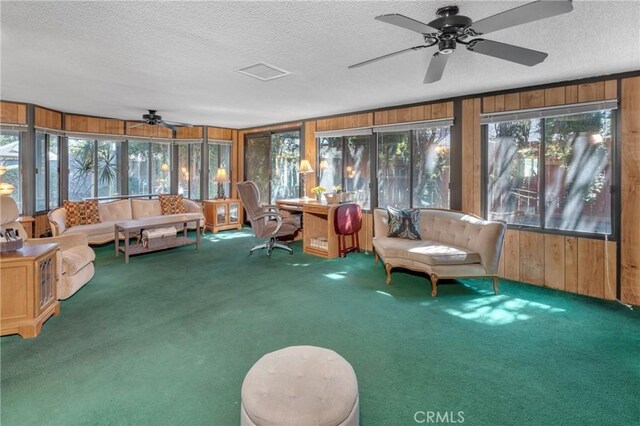 9945 Date St, Fontana, CA 92335 - sunroom featuring ceiling fan, wooden walls, a textured ceiling, and carpet