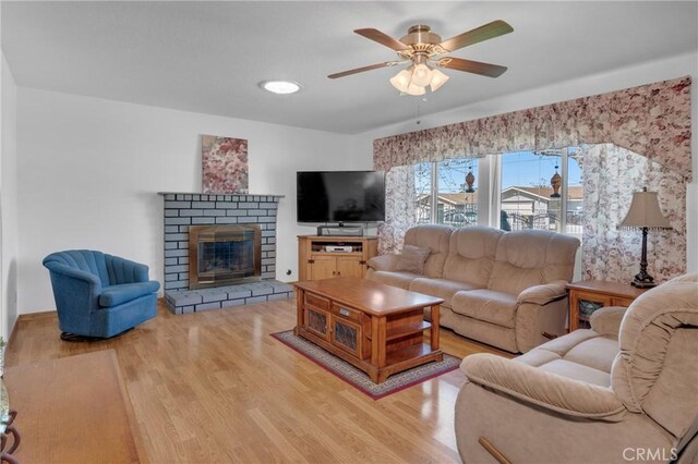 9945 Date St, Fontana, CA 92335 - living room with wood finished floors, a ceiling fan, and a brick fireplace