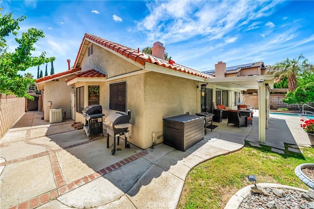 42635 56th St W, Lancaster, CA 93536 - rear view of house featuring stucco siding, a chimney, a patio area, and a fenced backyard