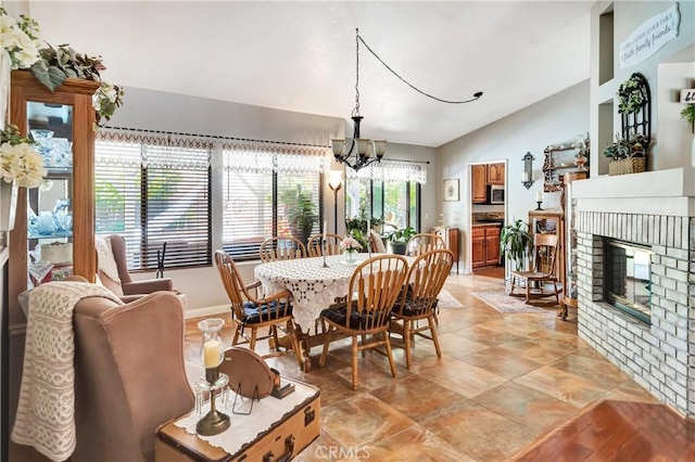 42635 56th St W, Lancaster, CA 93536 - dining room featuring vaulted ceiling, a chandelier, and a fireplace