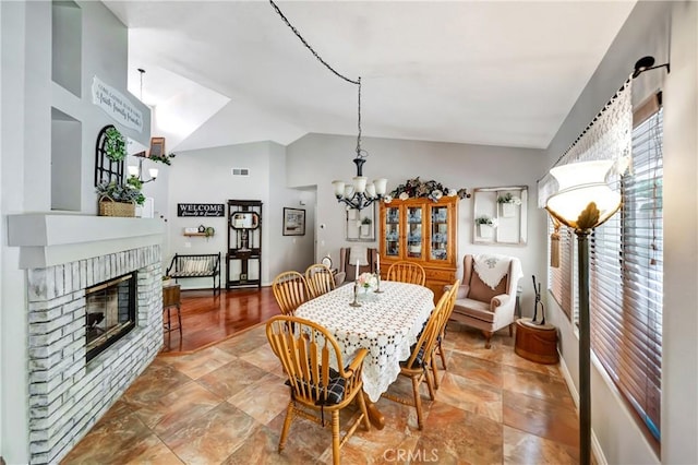 42635 56th St W, Lancaster, CA 93536 - dining space featuring vaulted ceiling, a brick fireplace, a chandelier, and baseboards