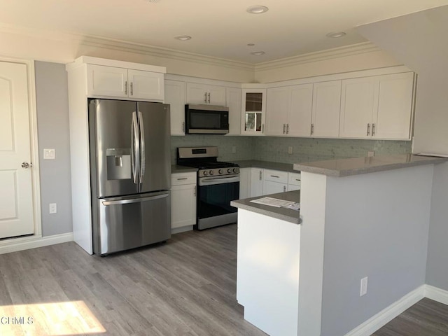 729 S Kern Ave, Los Angeles, CA 90022 - kitchen featuring appliances with stainless steel finishes, white cabinetry, crown molding, a peninsula, and glass insert cabinets