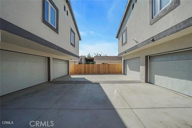 729 S Kern Ave, Los Angeles, CA 90022 - view of home's exterior with stucco siding, an attached garage, and driveway