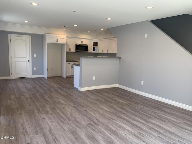 729 S Kern Ave, Los Angeles, CA 90022 - kitchen with stainless steel microwave, white cabinets, wood finished floors, ornamental molding, and baseboards