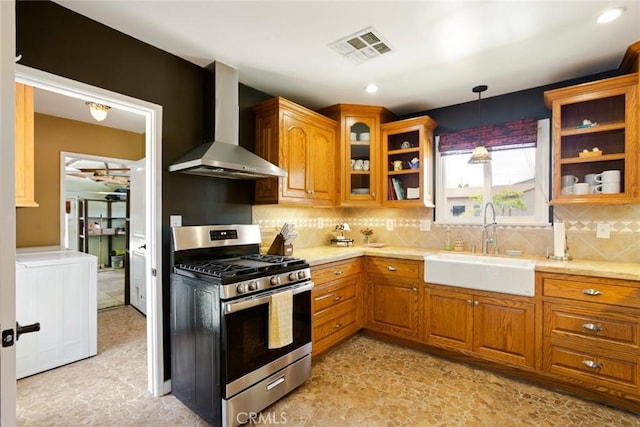 544 N California St, Burbank, CA 91505 - kitchen featuring stainless steel range with gas cooktop, wall chimney exhaust hood, brown cabinets, decorative backsplash, and glass insert cabinets