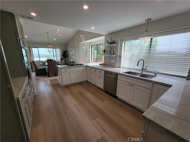 2722 Olympia Dr, Carlsbad, CA 92010 - kitchen with dishwasher, light stone counters, a peninsula, lofted ceiling, and light wood finished floors