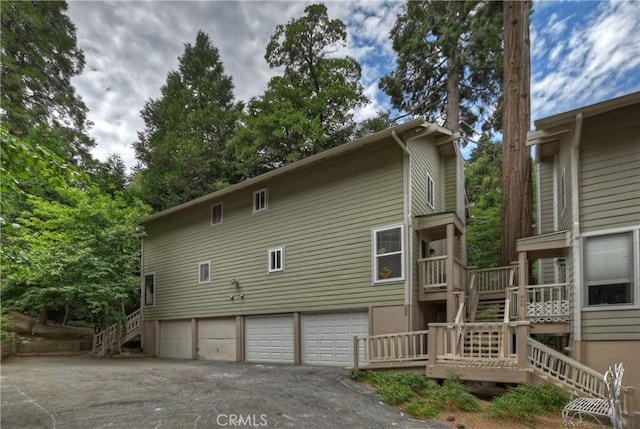 209 Cool Creek Ln Unit 10, Lake Arrowhead, CA 92352 - view of home's exterior featuring stairs, asphalt driveway, a garage, and a deck