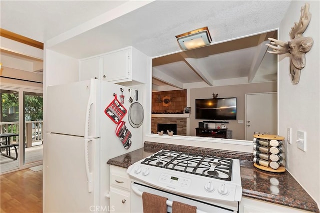 209 Cool Creek Ln Unit 10, Lake Arrowhead, CA 92352 - kitchen featuring white appliances, beamed ceiling, white cabinetry, dark stone counters, and wood finished floors