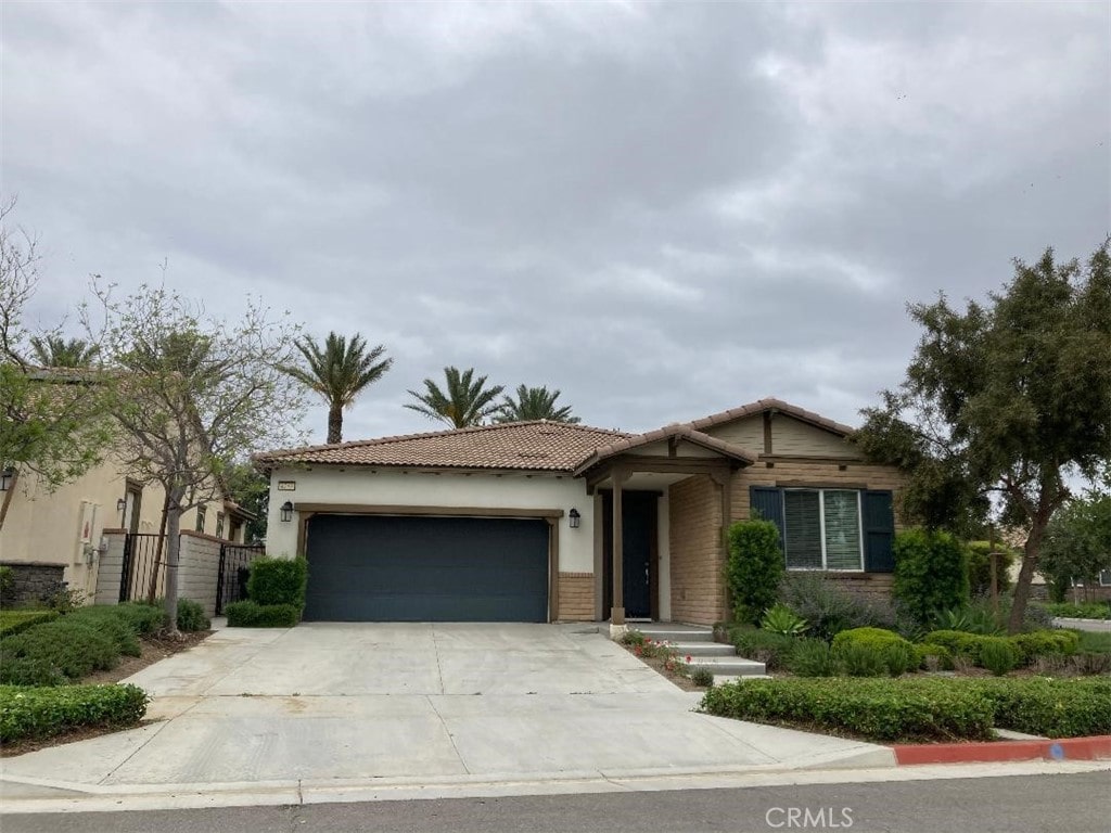 4253 E Sonrisa Privado, Ontario, CA 91761 - view of front of home with a garage, concrete driveway, a tile roof, and stucco siding