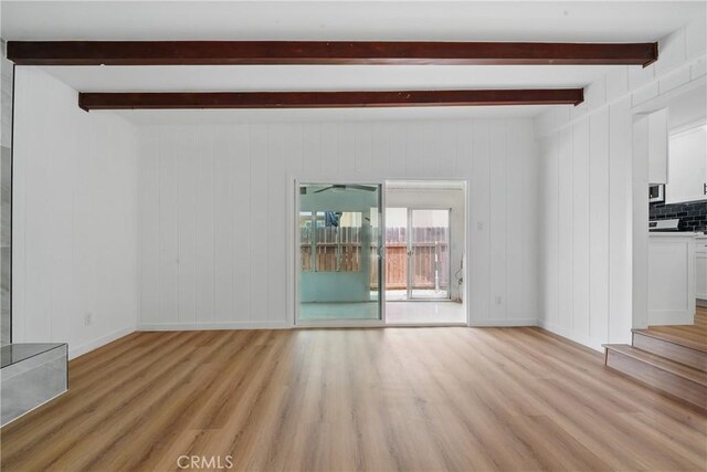 611 S Thorson Ave, Compton, CA 90221 - unfurnished living room featuring light wood finished floors, beamed ceiling, and baseboards