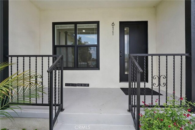 611 S Thorson Ave, Compton, CA 90221 - view of exterior entry featuring stucco siding, a porch, and a gate