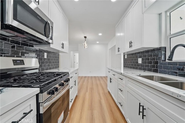 611 S Thorson Ave, Compton, CA 90221 - kitchen with appliances with stainless steel finishes, a sink, light wood-type flooring, white cabinets, and recessed lighting